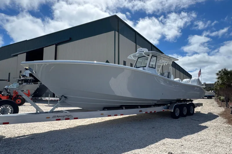 Slide: The Image of 2026 Yellowfin 36 Offshore boat on trailer, parked outside a large building. - 7