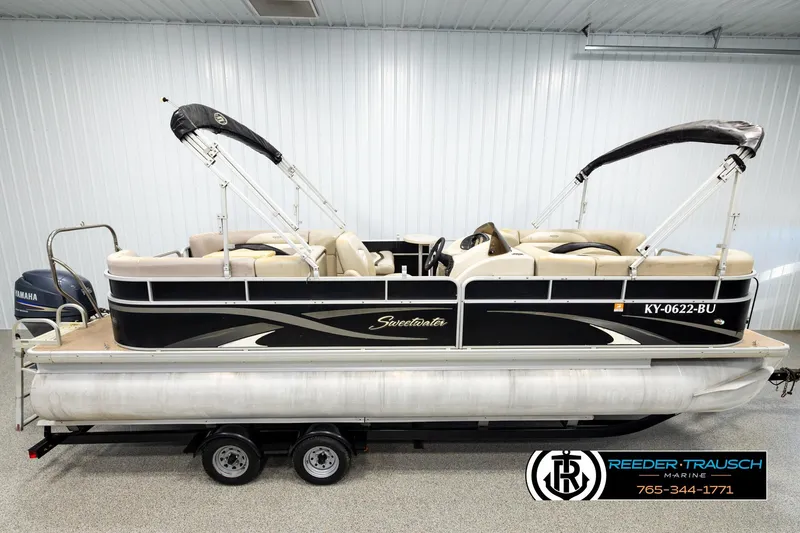 The Image of 2011 Godfrey SW2486 pontoon boat with Yamaha motor, displayed indoors on a trailer. - 1
