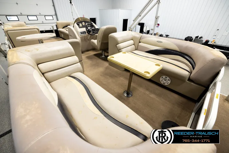 Slide: The Image of Interior of a 2011 Godfrey sw2486 pontoon boat with beige seating and table. - 11