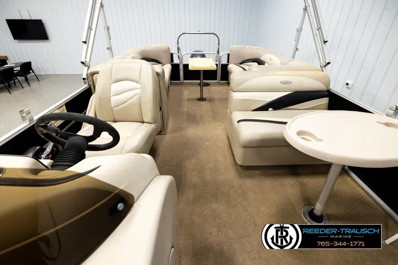 Slide: The Image of Interior of a 2011 Godfrey SW2486 pontoon boat with beige seating and steering wheel. - 14