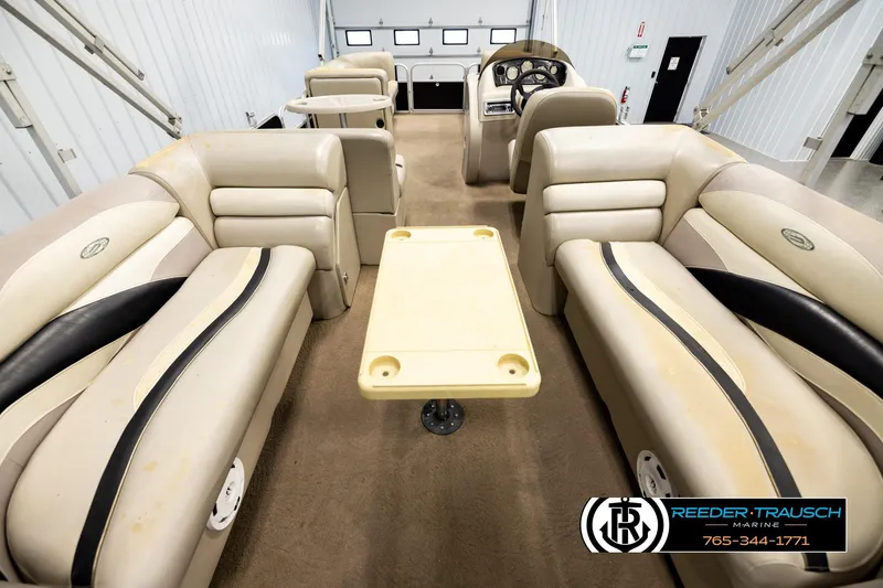 Slide: The Image of Interior of a 2011 Godfrey SW2486 pontoon boat with beige seating and table. - 16