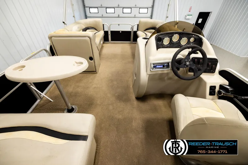 Slide: The Image of Interior of a 2011 Godfrey SW2486 boat with beige seating and steering console. - 17