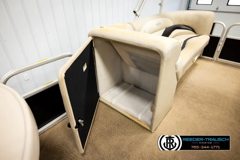 Slide: The Image of Open storage compartment in a 2011 Godfrey SW2486 boat, beige interior, Reeder-Trausch Marine logo. - 21
