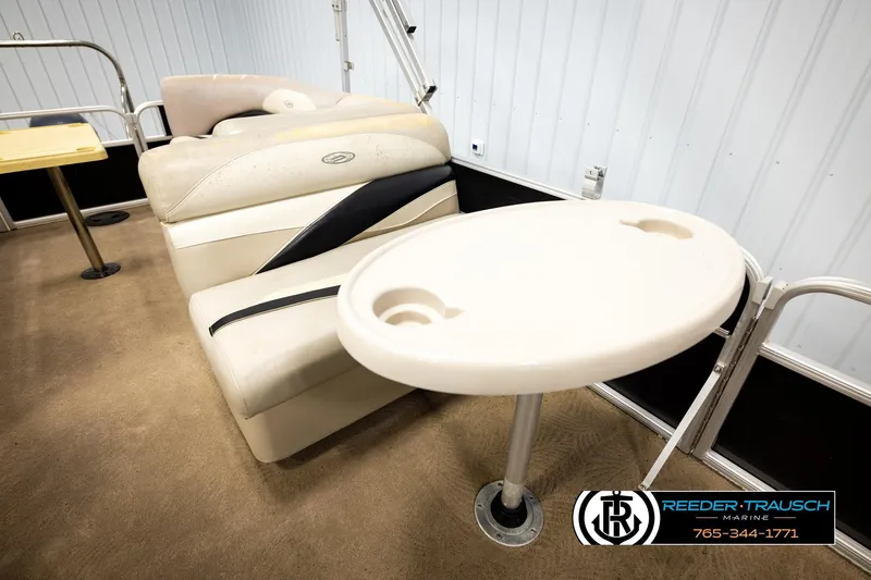 Slide: The Image of 2011 Godfrey SW2486 boat interior with seating and table, Reeder-Trausch Marine logo visible. - 22