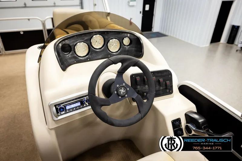 Slide: The Image of Steering console of 2011 Godfrey SW2486 boat with gauges and controls in showroom. - 29