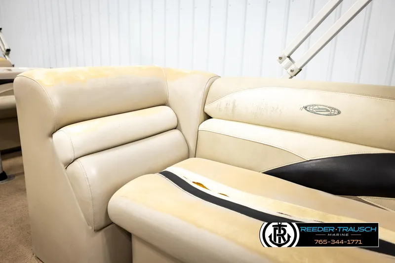 Slide: The Image of Beige leather seating on 2011 Godfrey SW2486 boat, slight wear, Reeder-Trausch Marine logo visible. - 37