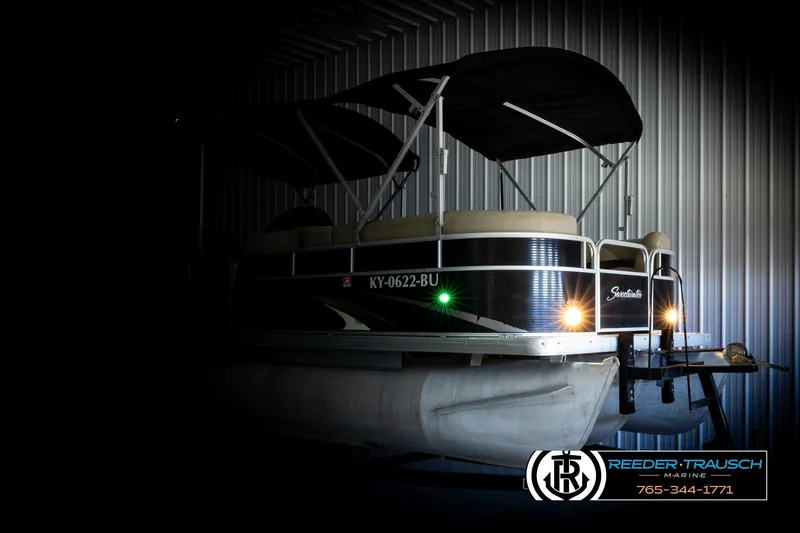 Slide: The Image of 2011 Godfrey SW2486 pontoon boat in storage with canopy and lights on. - 4