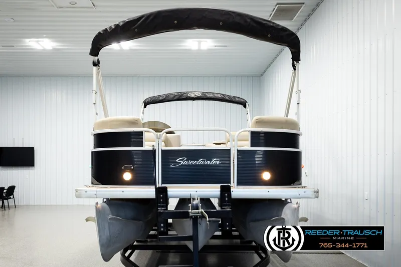 Slide: The Image of 2011 Godfrey SW2486 pontoon boat in showroom, featuring black and white design. - 8