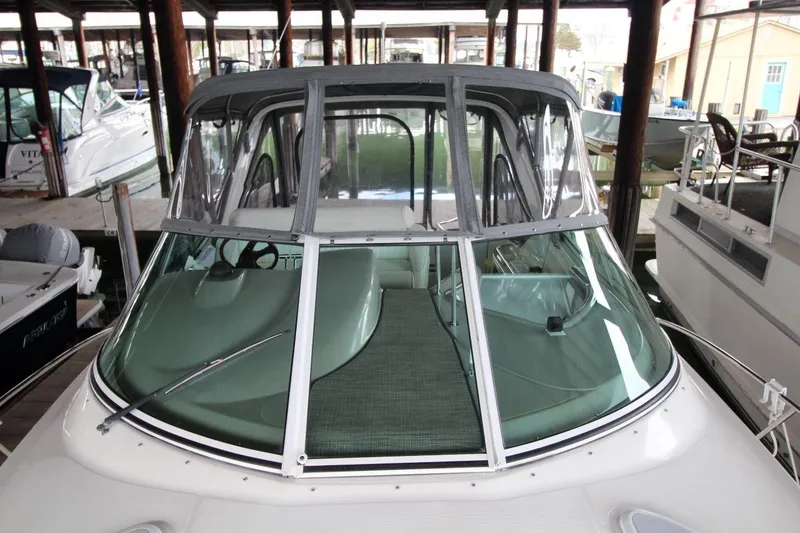 Slide: The Image of 2004 Cruisers Yachts 320 Express helm with white seating and Garmin navigation system. - 10