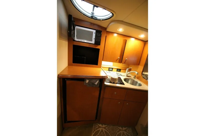 Slide: The Image of 2004 Cruisers Yachts 320 Express interior with cozy seating and wooden table. - 14