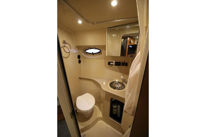 Slide: The Image of Interior of 2004 Cruisers Yachts 320 Express with beige leather sofa and ambient lighting. - 16