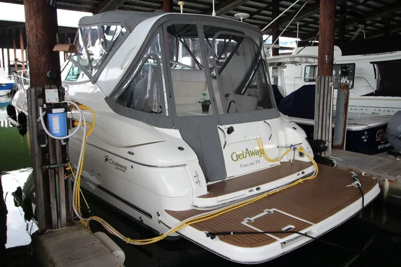 Slide: The Image of 2004 Cruisers Yachts 320 Express docked in marina, rear view with canopy. - 2