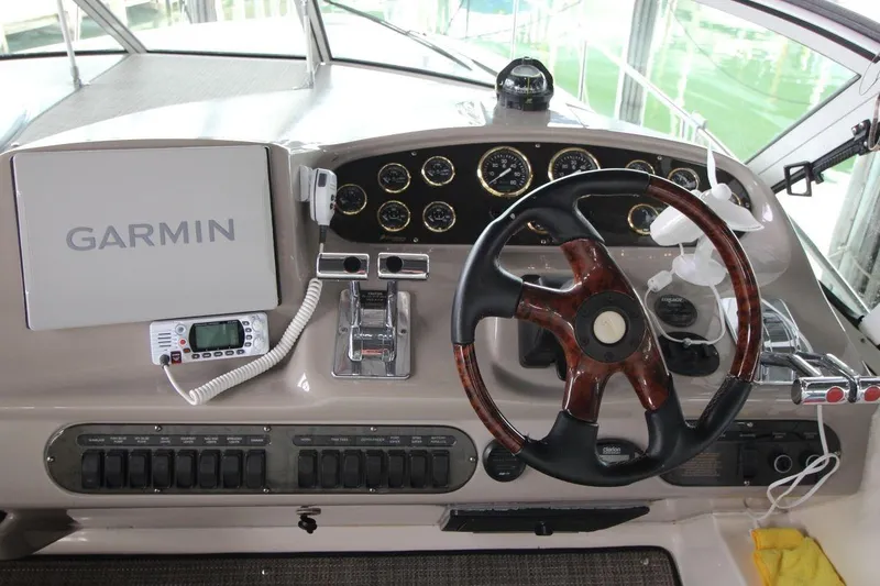 Slide: The Image of 2004 Cruisers Yachts 320 Express interior with seating and table, docked at marina. - 8