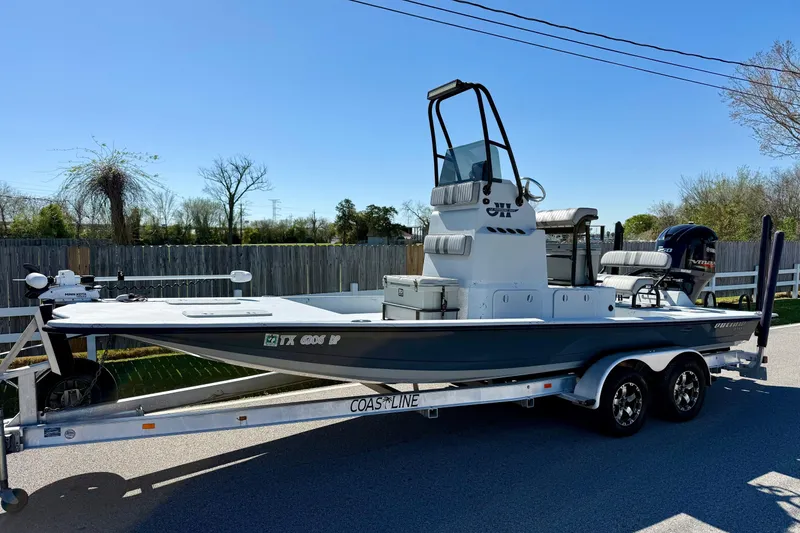 The Image of JH Performance boat on trailer, parked outdoors, clear sky background. - 1