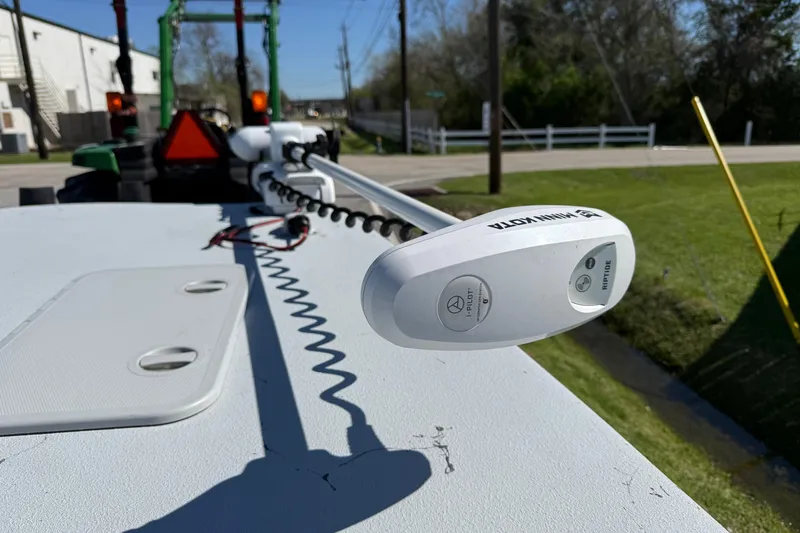 Slide: The Image of Minn Kota Riptide trolling motor on JH Performance boat, parked near green grass and road. - 16