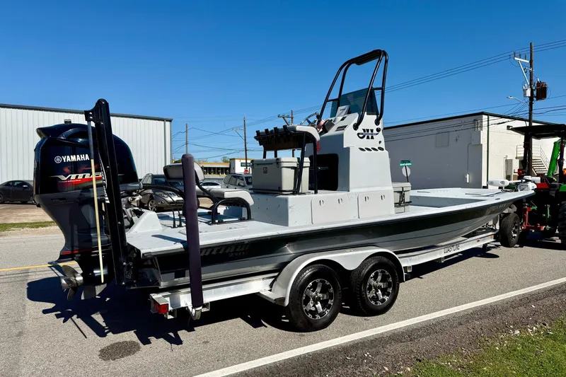 Slide: The Image of JH Performance boat with Yamaha engine on trailer, parked outdoors under clear blue sky. - 4