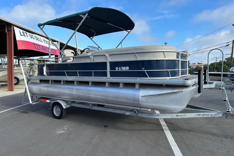 The Image of 2020 Godfrey SR 206 C pontoon boat on trailer, parked outdoors under blue sky. - 1