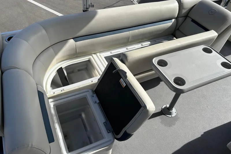 Slide: The Image of 2020 Godfrey SR 206 C boat interior with seating, storage compartments, and table. - 16