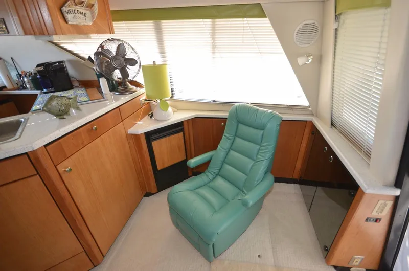 Slide: The Image of Interior of 1998 Bayliner 3988 yacht with green chair. - 18