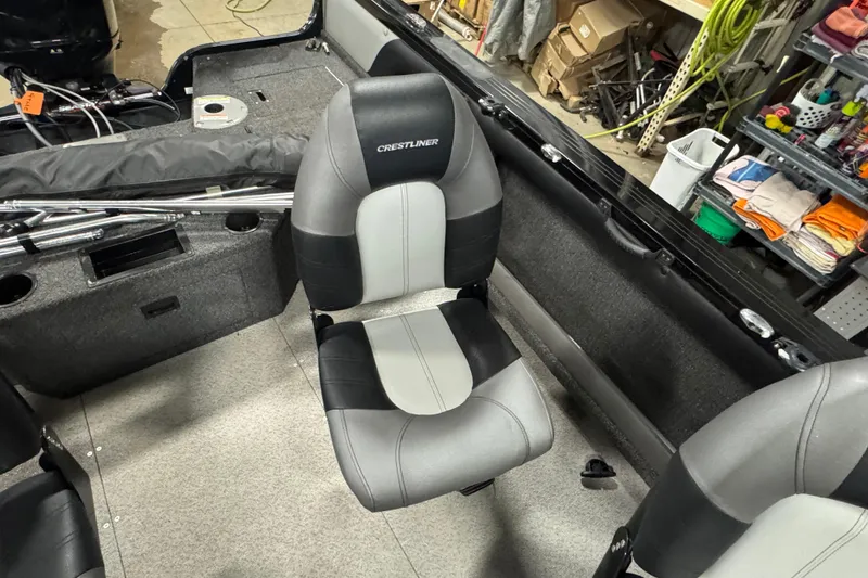 Slide: The Image of 2020 Crestliner 1850 Super Hawk interior with gray and black seating in a workshop. - 10