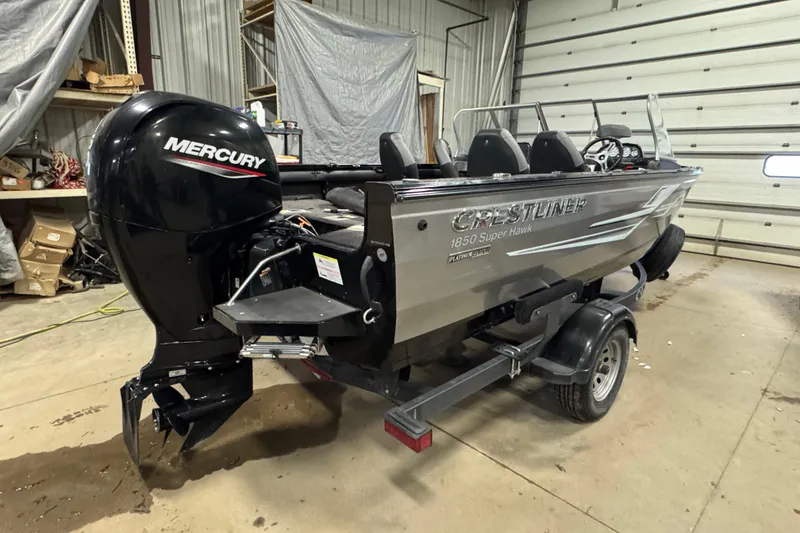 Slide: The Image of 2020 Crestliner 1850 Super Hawk boat with Mercury engine in a garage setting. - 4