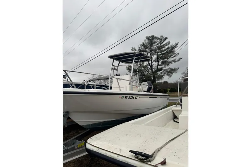 The Image of 2005 Boston Whaler 190 Nantucket boat on trailer, overcast sky, tree in background. - 0