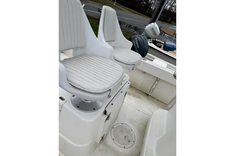 Slide: The Image of 2005 Boston Whaler 190 Nantucket boat interior with white cushioned seats. - 4