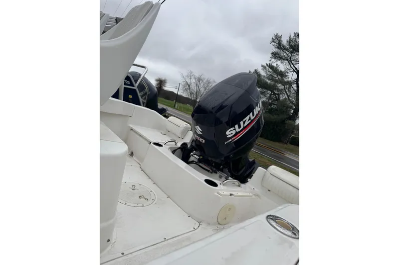 Slide: The Image of 2005 Boston Whaler 190 Nantucket with Suzuki outboard motor, parked outdoors. - 8