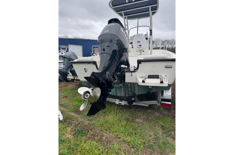 Slide: The Image of 2005 Boston Whaler 190 Nantucket boat with outboard motor, parked on grass. - 9