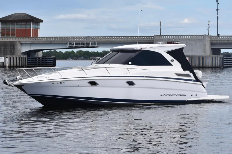The Image of 2020 Regal 35 Sport Coupe boat on water near a bridge. - 0