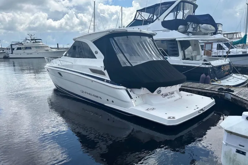 The Image of 2020 Regal 35 Sport Coupe cruising on a calm river under clear skies. - 2