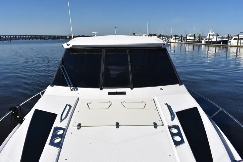 Slide: The Image of 2020 Regal 35 Sport Coupe on calm water near marina. - 20