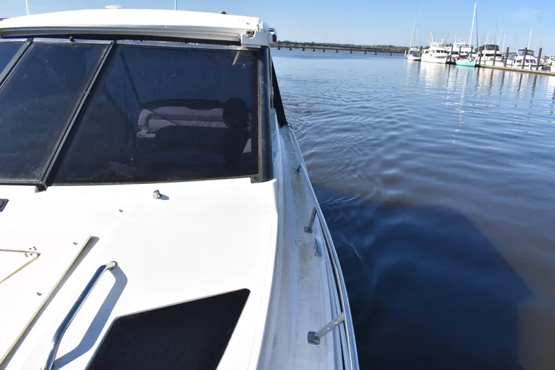 Slide: The Image of 2020 Regal 35 Sport Coupe cruising near marina with clear blue sky. - 21