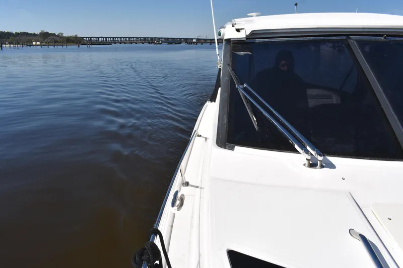 Slide: The Image of 2020 Regal 35 Sport Coupe cruising on calm waters near a bridge. - 22