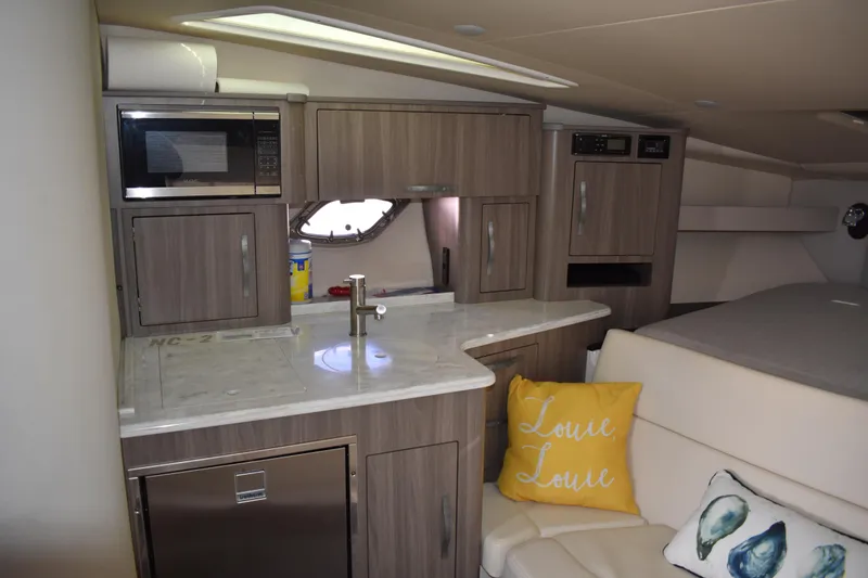 Slide: The Image of 2020 Regal 35 Sport Coupe interior with kitchenette, microwave, and cozy seating area. - 49