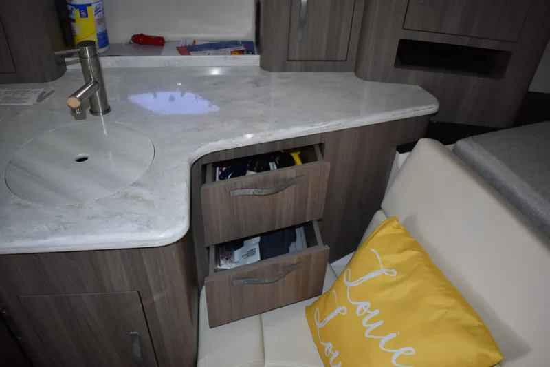 Slide: The Image of 2020 Regal 35 Sport Coupe interior with sink, drawers, and yellow pillow. - 55