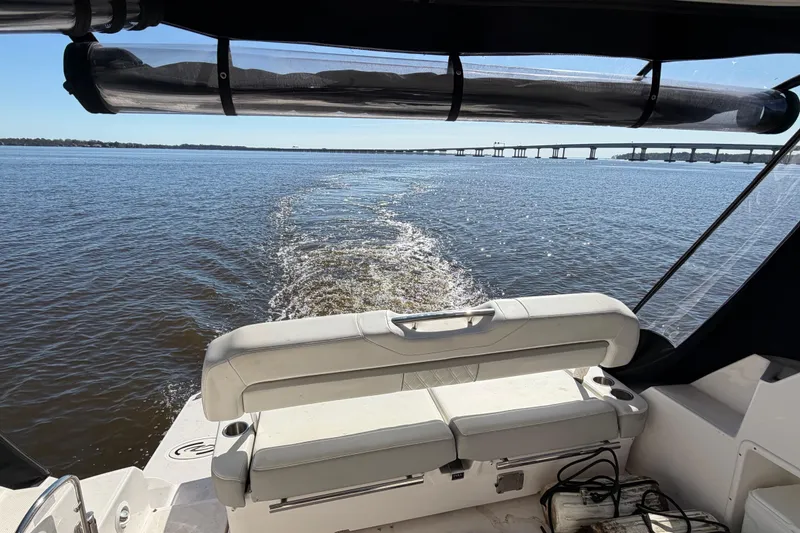 Slide: The Image of 2020 Regal 35 Sport Coupe cruising on open water with bridge in background. - 93