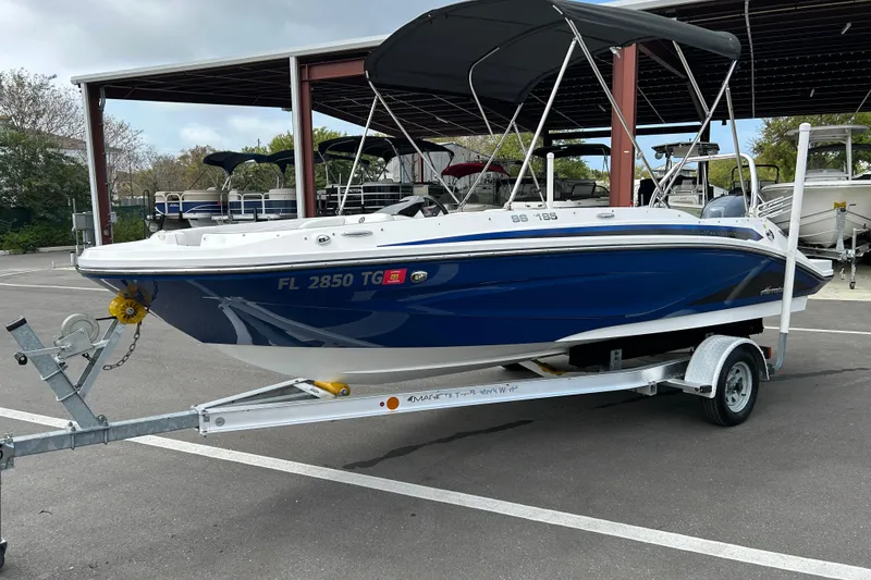 Slide: The Image of 2022 Hurricane SunDeck Sport 185 OB boat on trailer, parked in marina. - 5