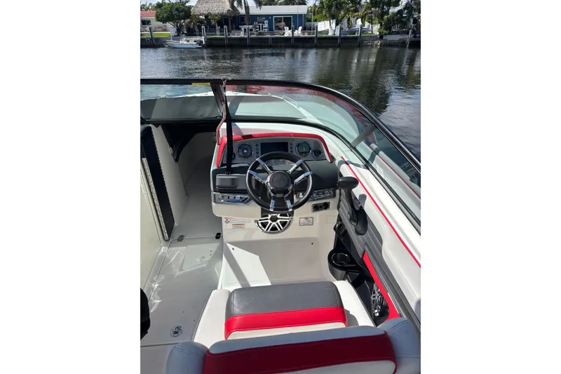 Slide: The Image of 2016 Regal 27 FasDeck RX boat interior with steering wheel and dashboard by the water. - 14