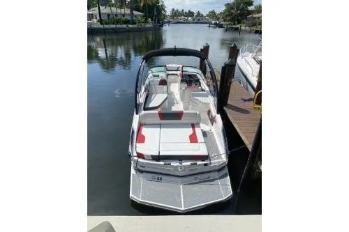 Slide: The Image of 2016 Regal 27 FasDeck RX boat docked on a calm waterfront. - 3
