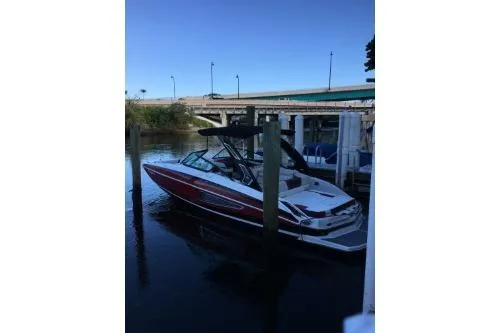 Slide: The Image of 2016 Regal 27 FasDeck RX boat docked by a bridge in calm waters. - 5