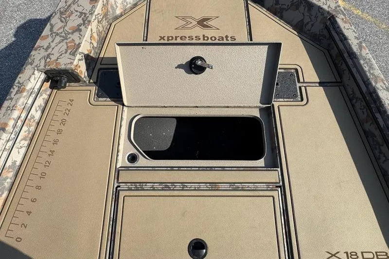 Slide: The Image of 2026 Xpress X18DB boat deck with storage compartments and measuring ruler. - 11