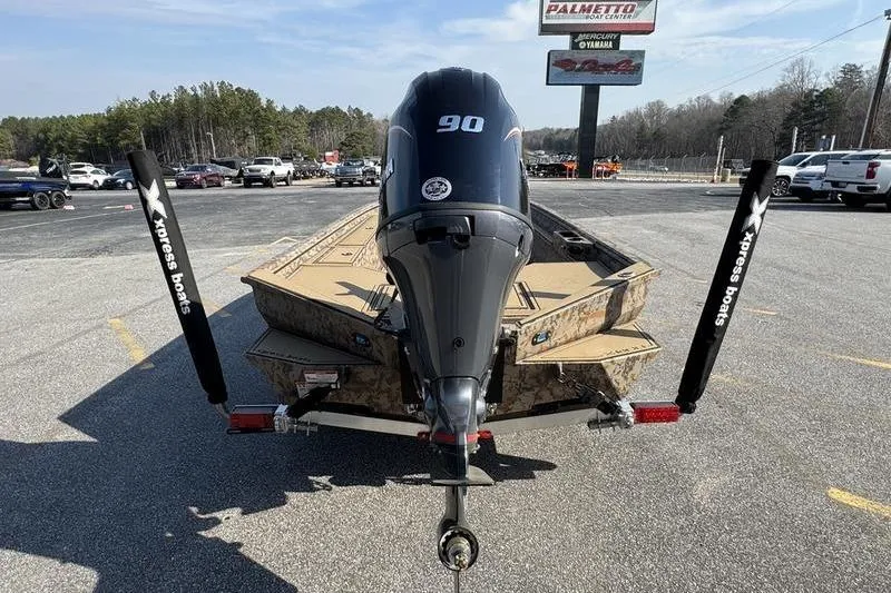 Slide: The Image of 2026 Xpress X18DB boat with 90HP engine on trailer in parking lot. - 2