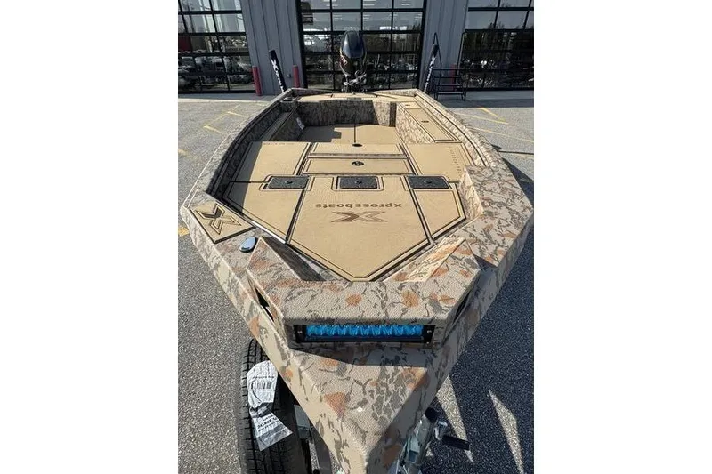Slide: The Image of 2026 Xpress X18DB boat with camouflage design, parked outdoors. - 5