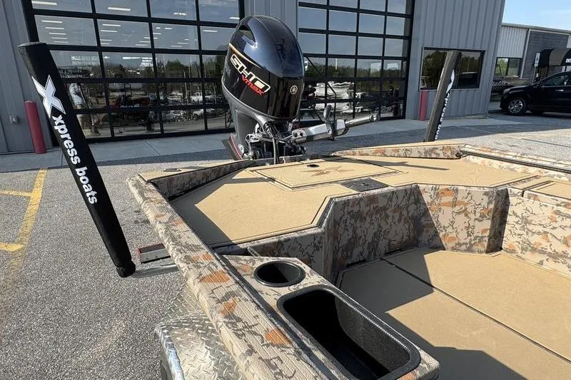 Slide: The Image of 2026 Xpress X18DB boat with camouflage design and powerful outboard motor. - 7