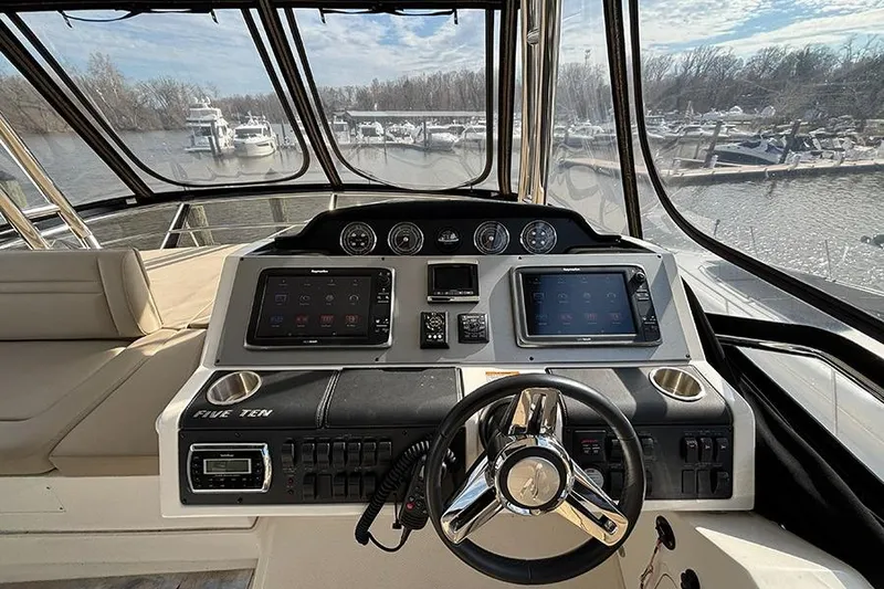Slide: The Image of 2015 Sea Ray 510 Flybridge helm with modern navigation controls and panoramic marina view. - 13