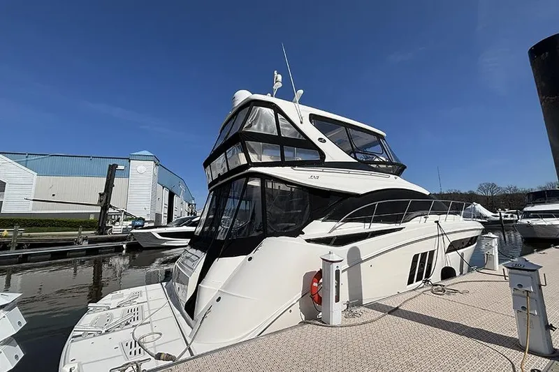 Slide: The Image of 2015 Sea Ray 510 Fly yacht docked at marina under clear blue sky. - 2