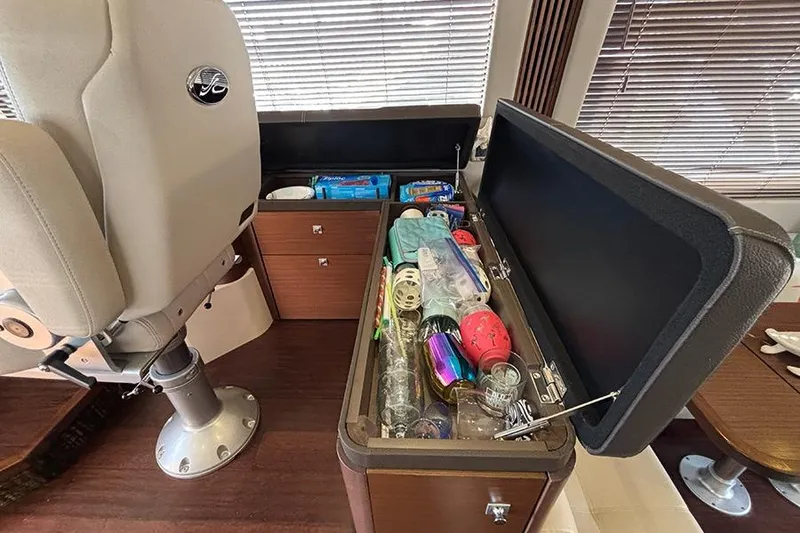 Slide: The Image of Interior of 2015 Sea Ray 510 Fly yacht with open storage compartment and various items. - 22