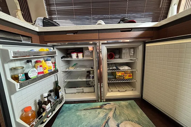 Slide: The Image of Open refrigerator in 2015 Sea Ray 510 Fly yacht kitchen, stocked with various condiments and food items. - 24