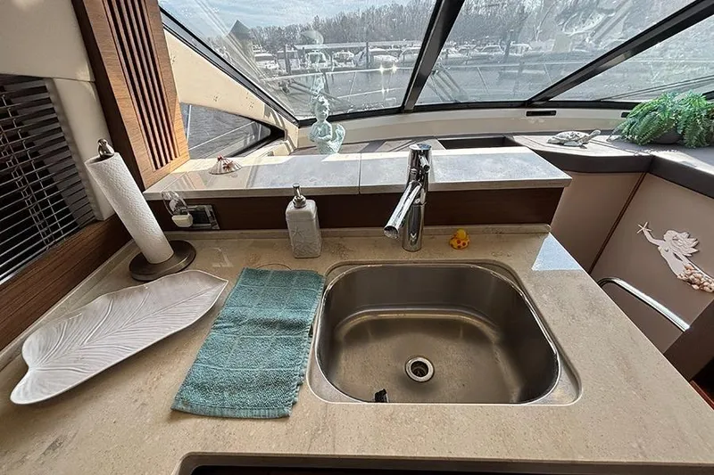 Slide: The Image of Luxurious 2015 Sea Ray 510 Fly yacht kitchen with sink and scenic window view. - 27